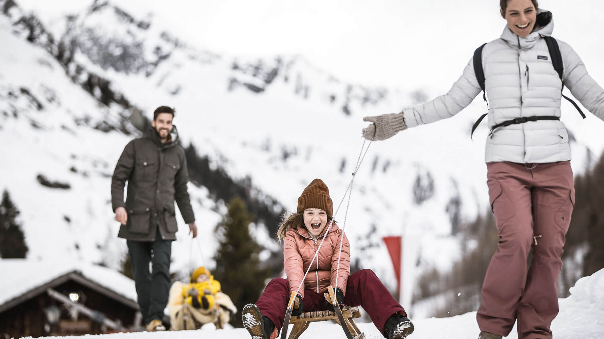 Familie beim Schlittenfahren - OLM Nature Escape