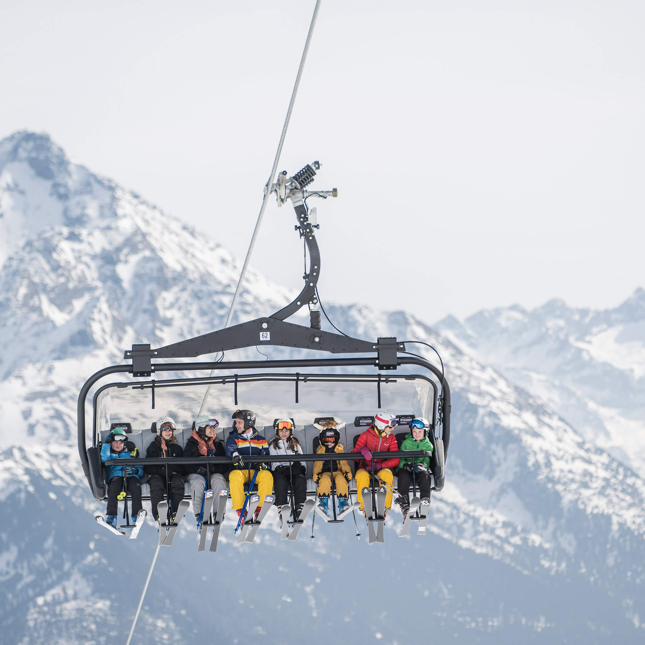 Acht Skifahrer im Sessellift auf dem Weg zur Bergstation - OLM Nature Escape