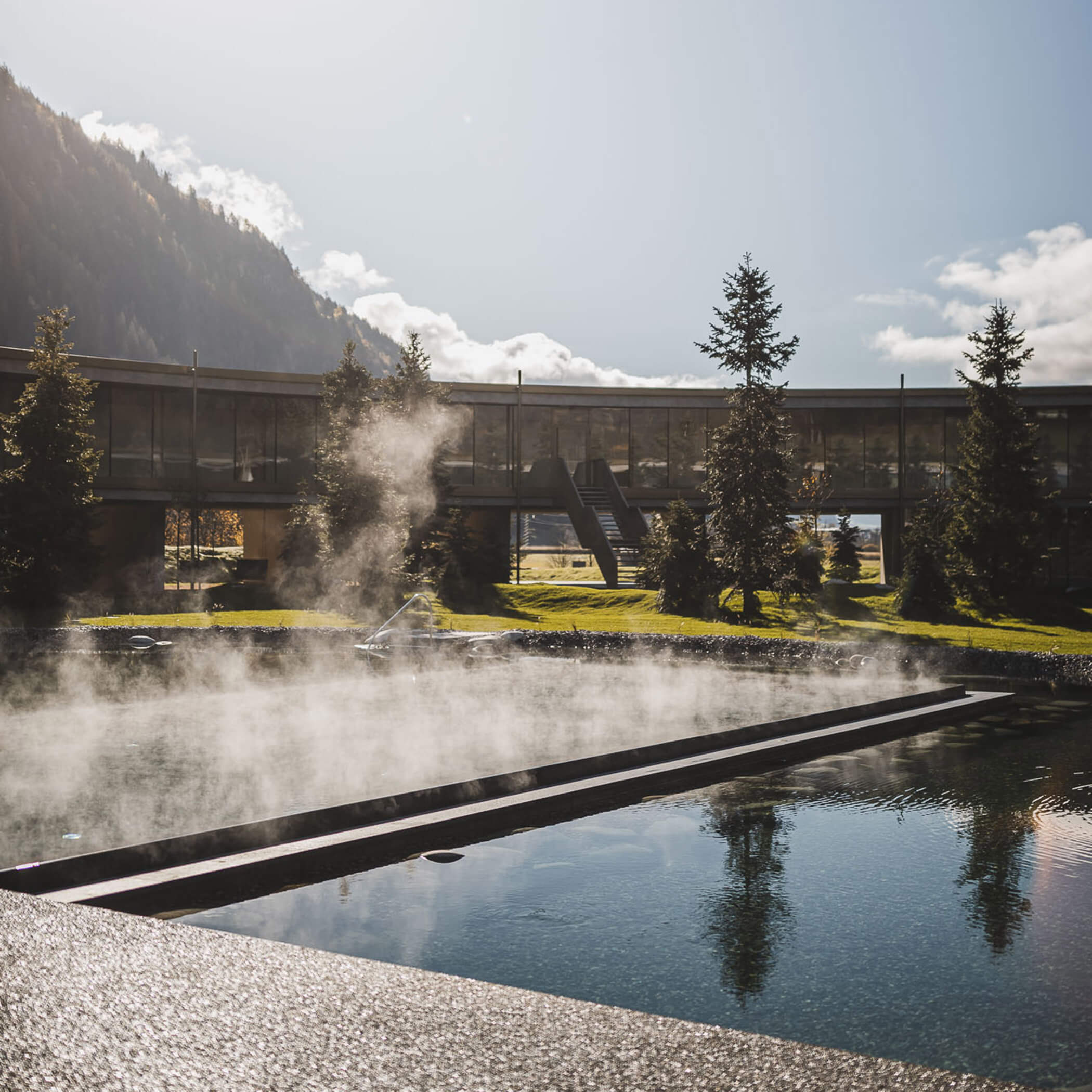 Outdoor pool at the aparthotel in summer with a green lawn - OLM Nature Escape