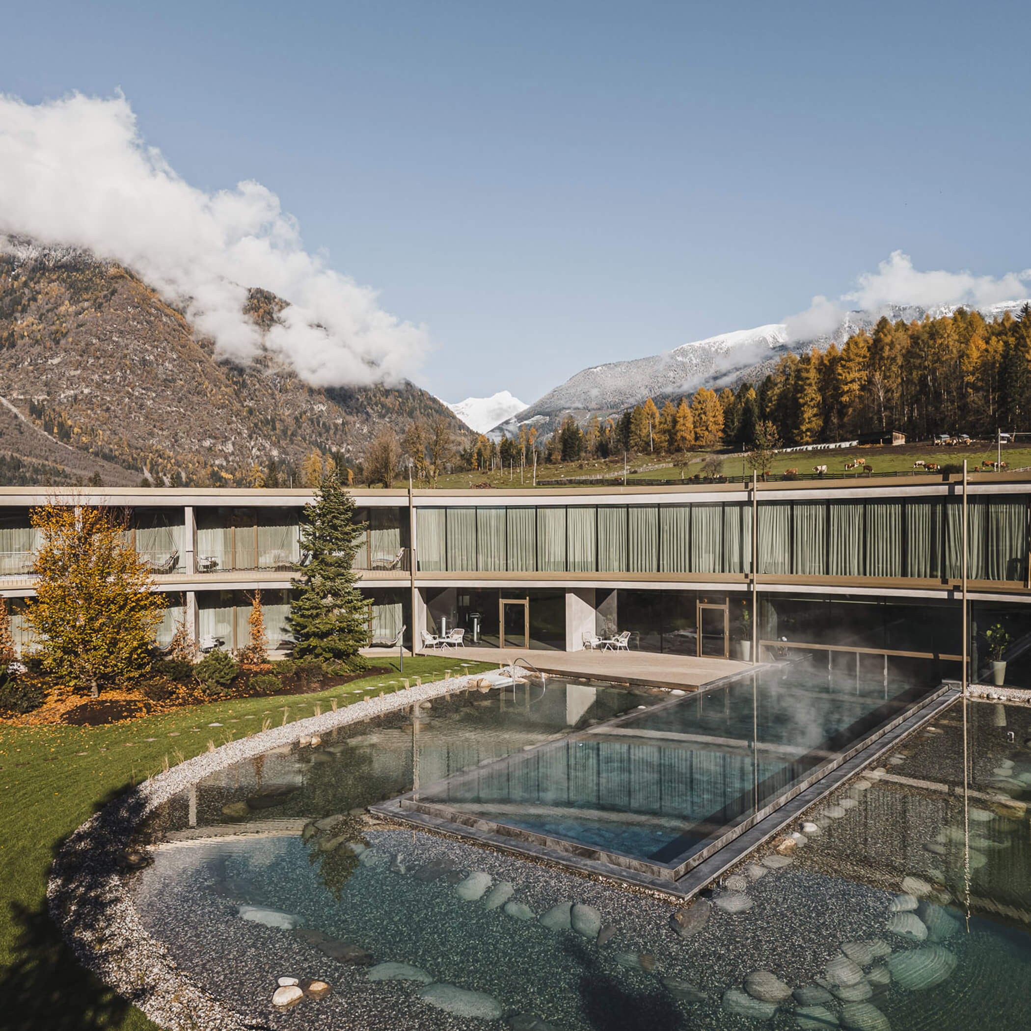 Beheiztes Außenschwimmbad mit Sicht in Richtung Felder und den Ahrntaler Bergen - OLM Nature Escape