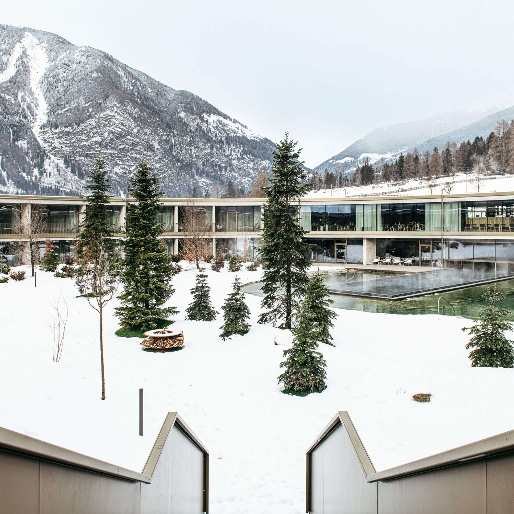 Verschneiter Innenhof mit Feuerstelle und beheiztem Außenpool - OLM Nature Escape