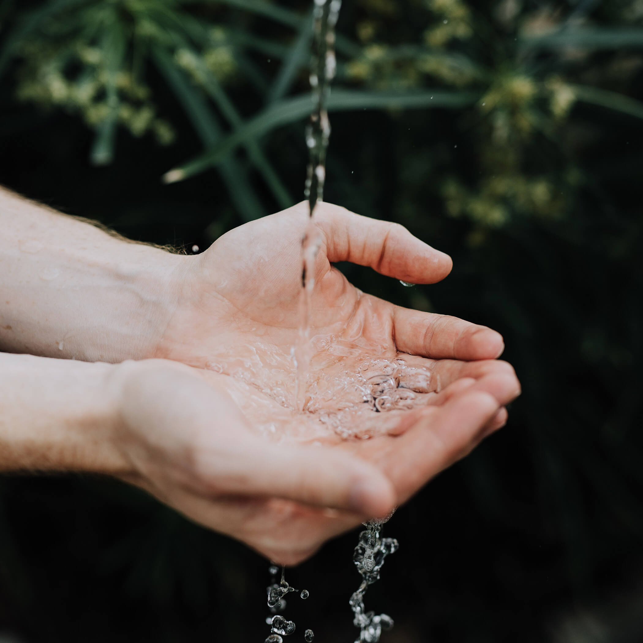 Wasser rinnt über Hände - OLM Nature Escape