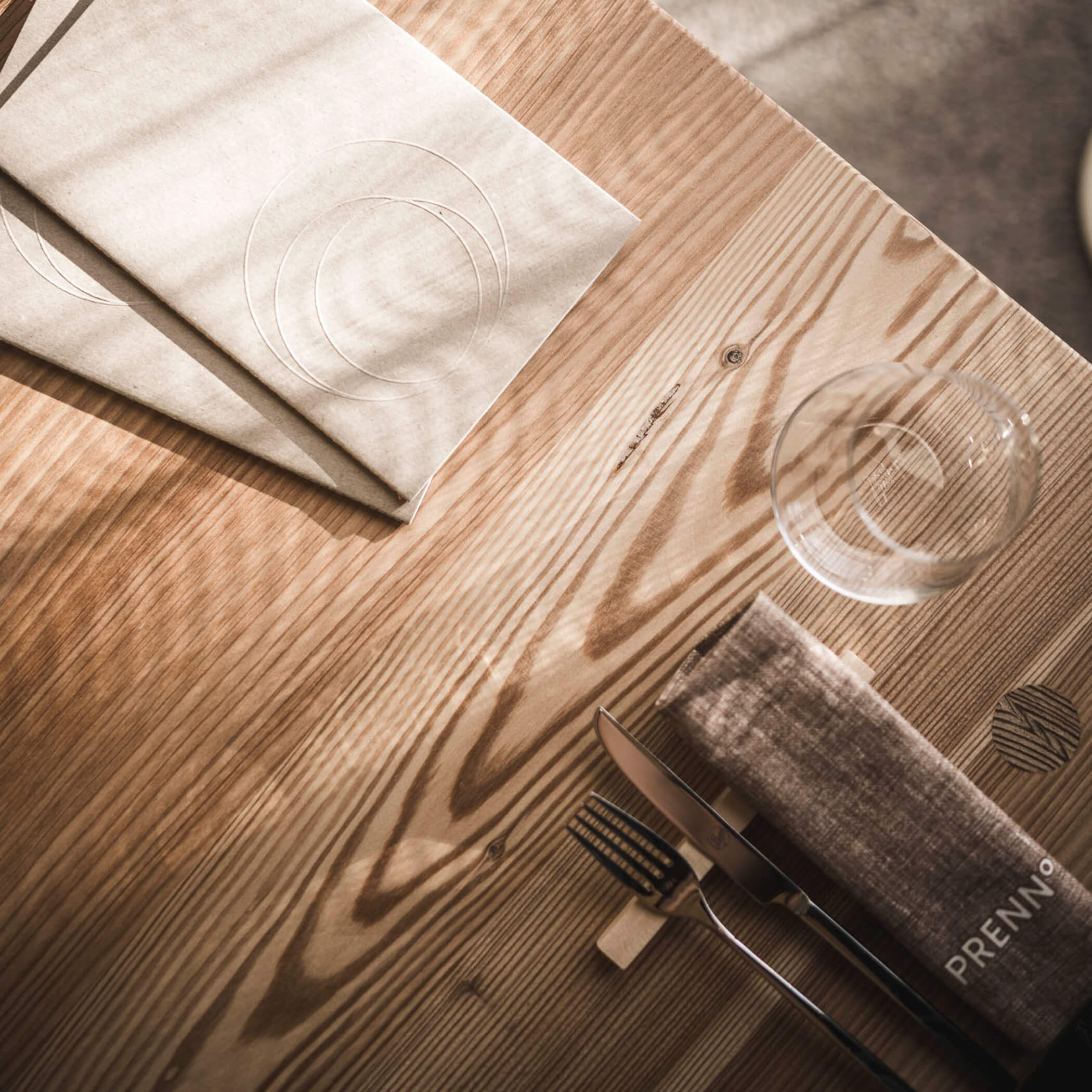 Speisekarten liegen auf dem gedeckten Tisch im Restaurant Prenn° - OLM Nature Escape