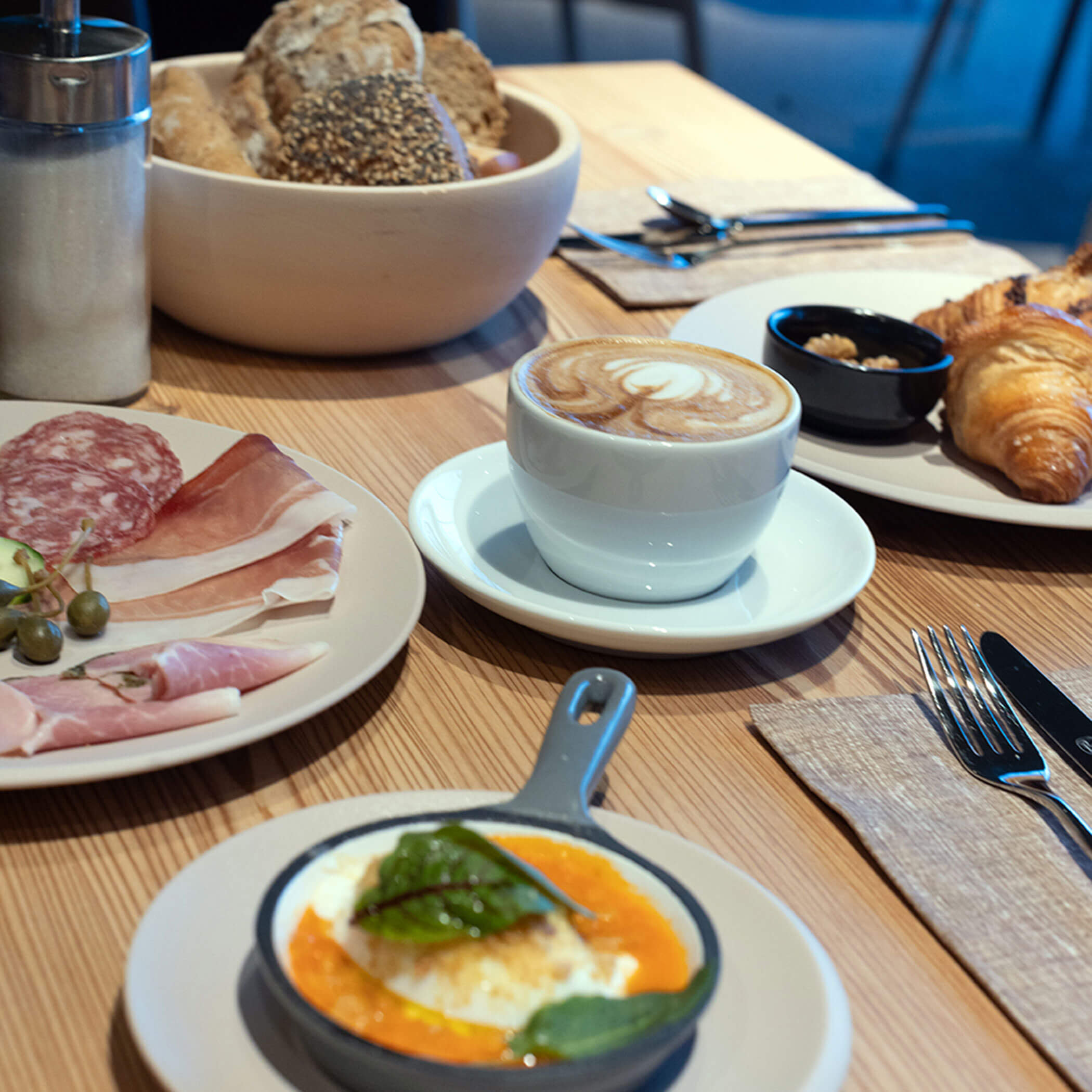 Gedeckter Frühstückstisch mit Kaffee, Brot und Croissant - OLM Nature Escape