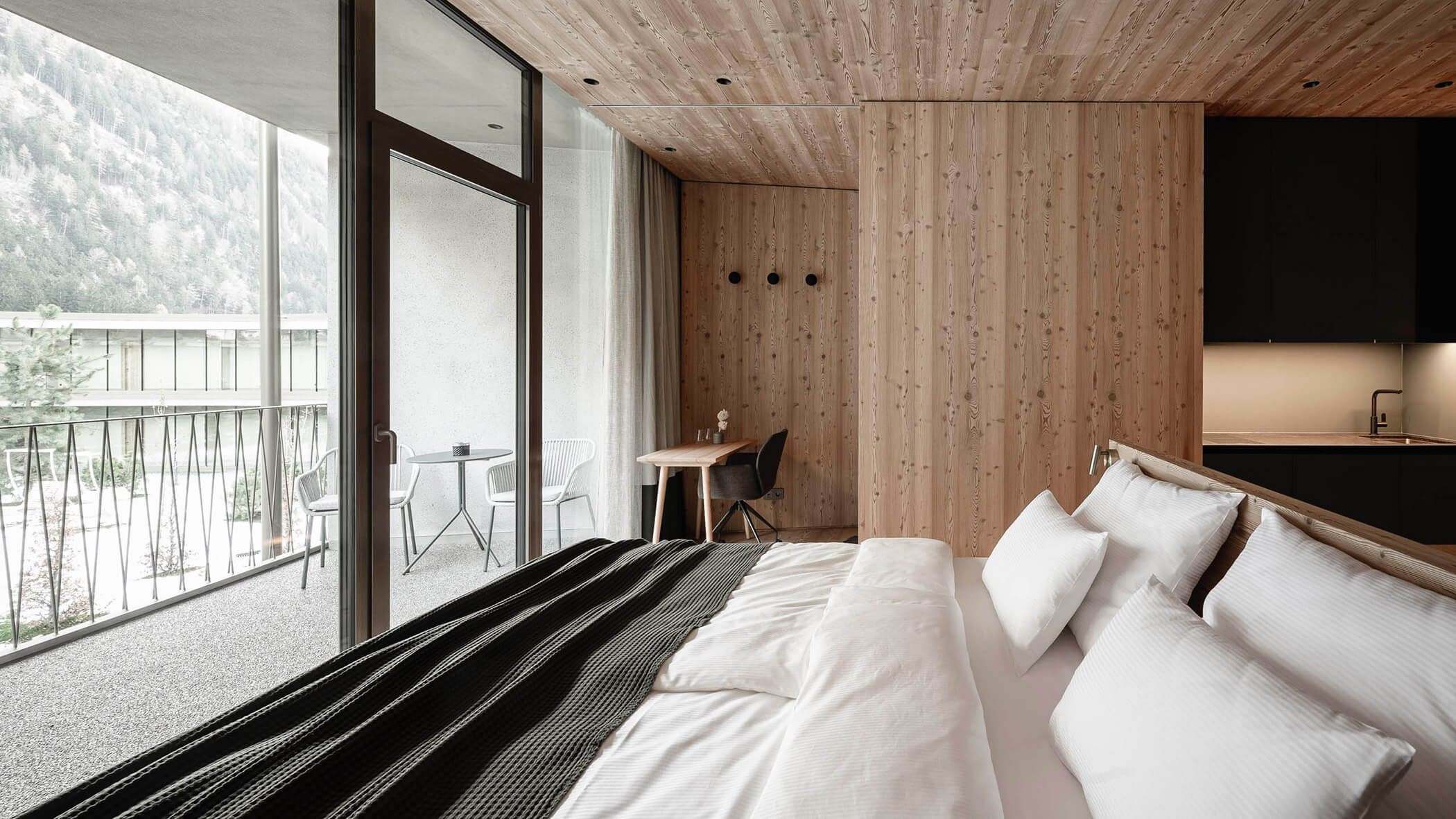 Schlafbereich der ApartSuite S mit Kingsize-Bett und Ausblick in den Innenhof - OLM Nature Escape