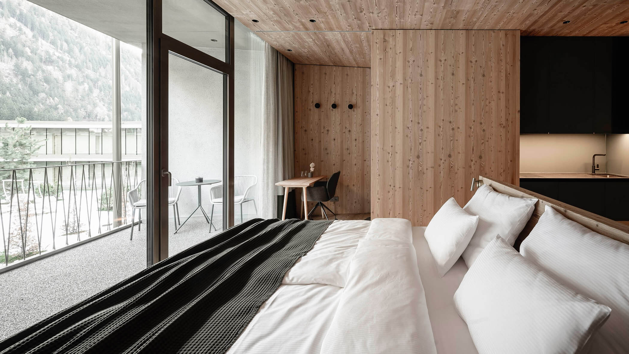 Kingsize-Bett in moderner ApartSuite mit Aussicht in den Innenhof - OLM Nature Escape