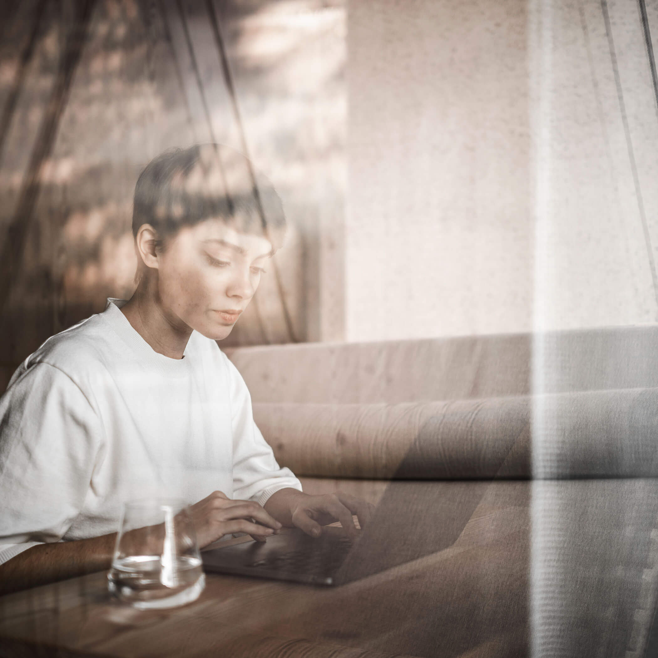 Frau macht Workation in Südtirol und arbeitet am PC - OLM Nature Escape