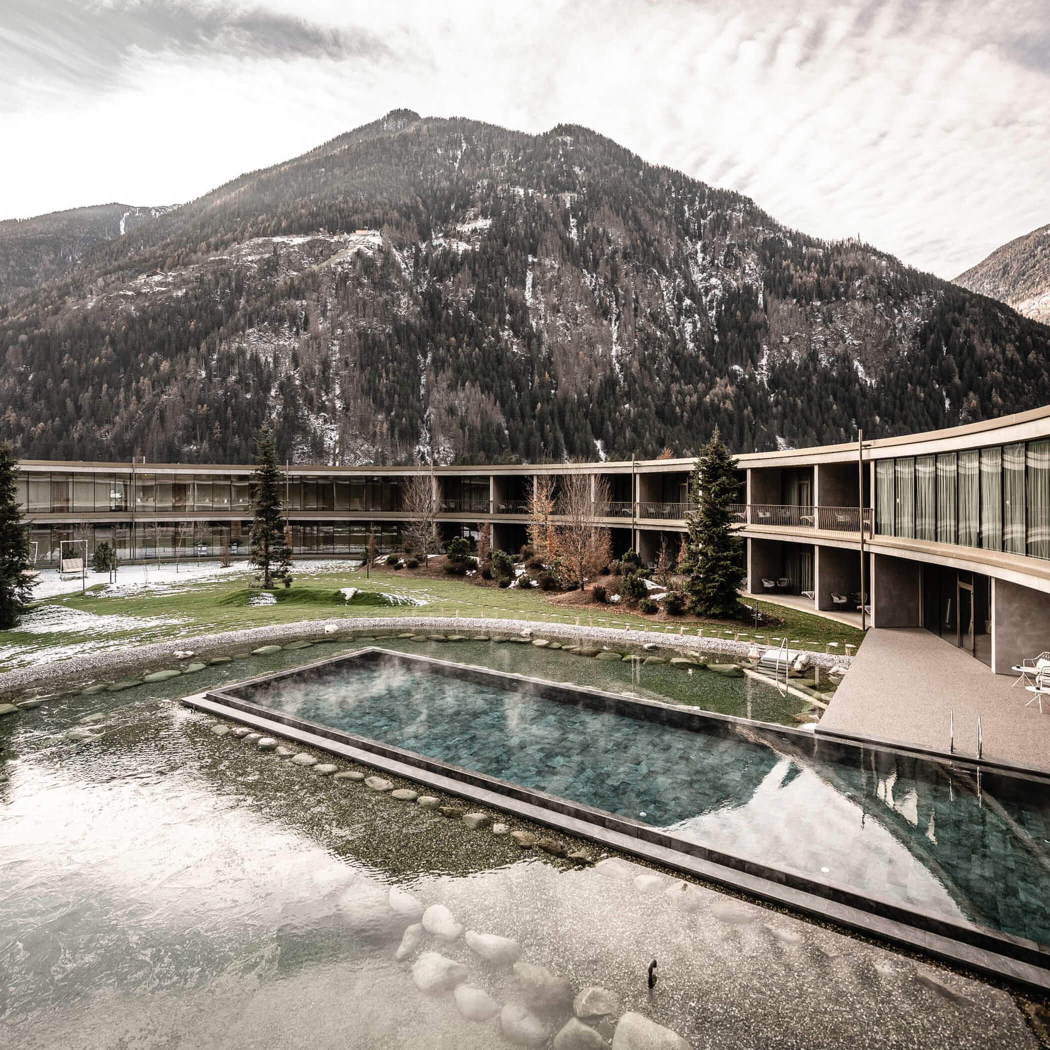 Beheizter Außenpool mit Blick auf die verschneiten Berge - OLM Nature Escape