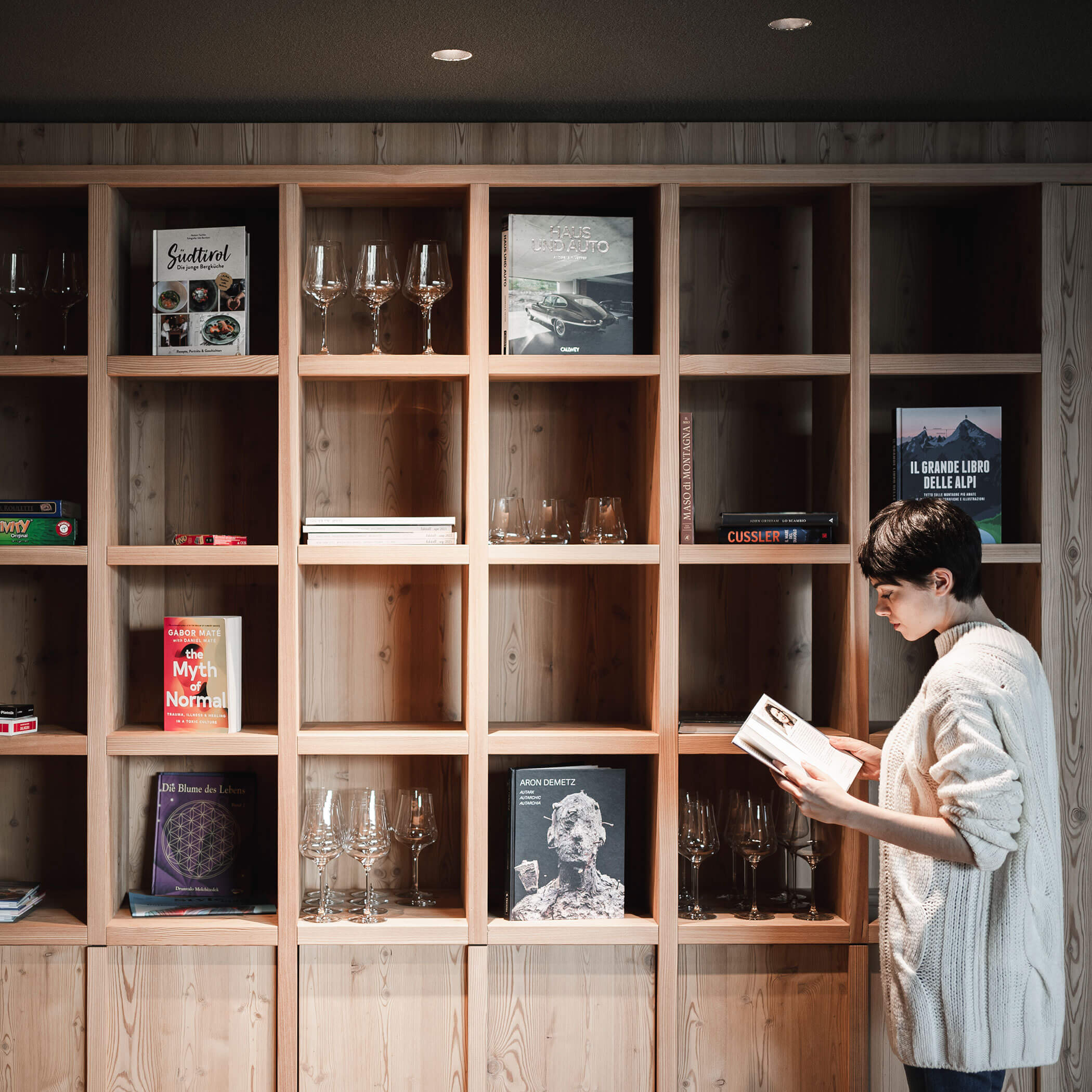 Woman rummaging through bookshelf - OLM Nature Escape