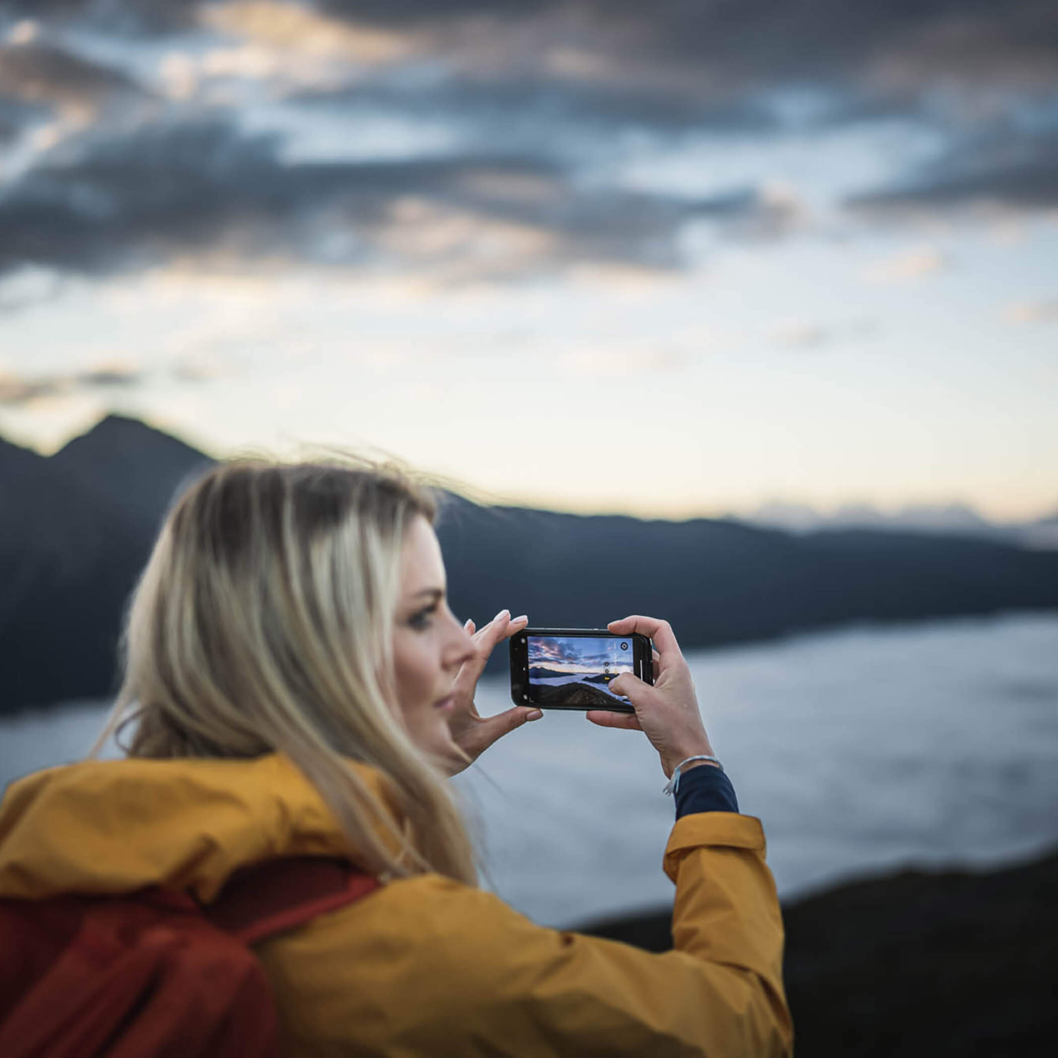 Woman photographing the sunset in the South Tyrolean mountains - OLM Nature Escape